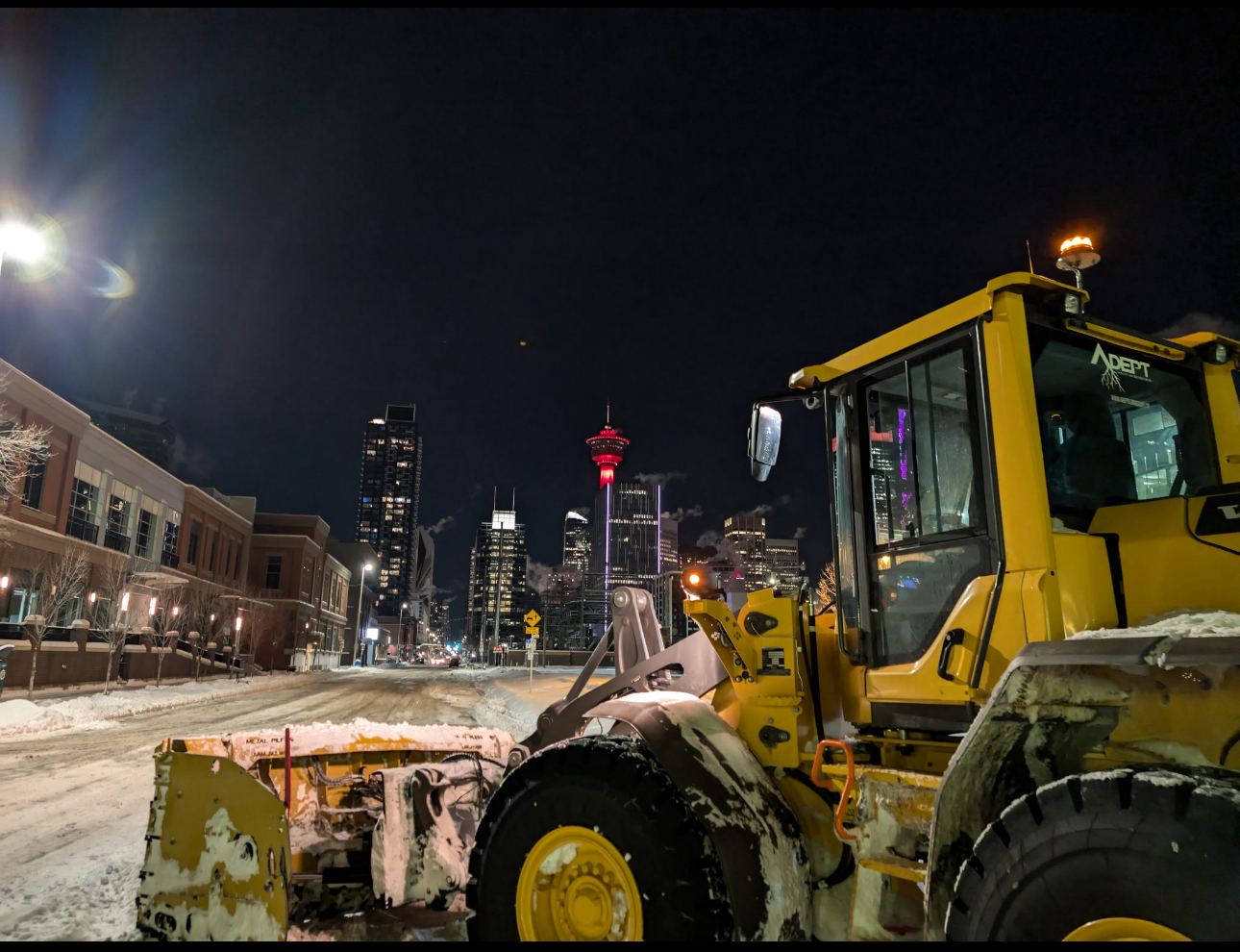 Adept loader clearing a downtown Calgary street at night